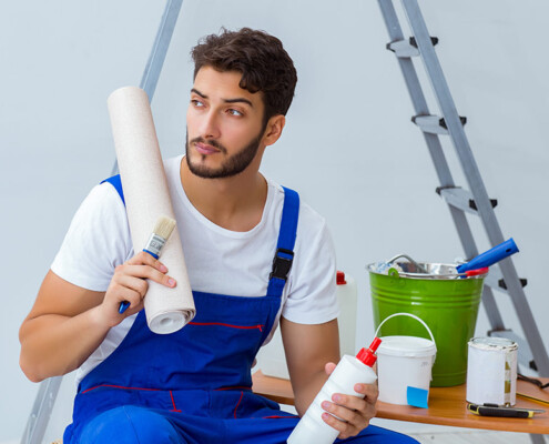 Reparateur bei Renovierungsarbeiten im Haus mit Papiertapete