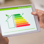 Ein Mann schaut auf ein Tablet, das die Energiebilanz seines Hauses anzeigt | Energieausweis