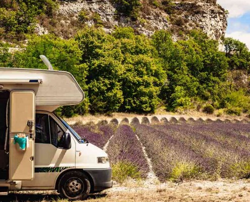 Ein Wohnmobil auf einem Feld vor einem Felsen in Südeuropa | Immobilienverrentung