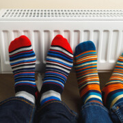 legs with colorful socks in front of heating radiator; Neues GEG