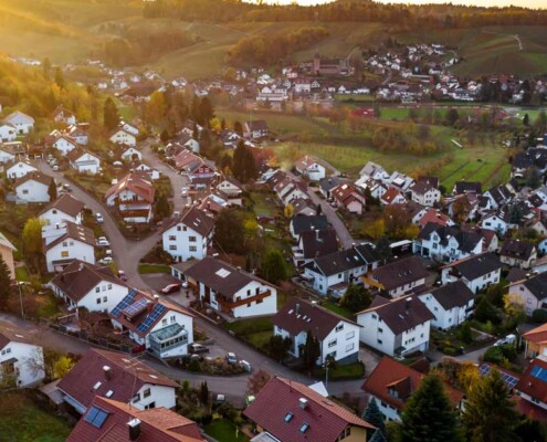 die Draufsicht auf ein Meer von deutschen Einfamilienhäusern, welche den Immobilienmarkt symbolisieren sollen