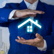 ein Makler hält ein digitales Haus aus Licht in den Händen