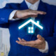ein Makler hält ein digitales Haus aus Licht in den Händen