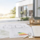 Dokumente, Grundrisse, Energieausweis, Schlüssel und Hausmodell auf einem Tisch als Symbol für wichtige Unterlagen beim Immobilienverkauf. - Verkaufsunterlagen
