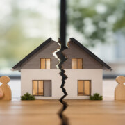 Geteiltes Hausmodell mit zwei Holzfiguren symbolisiert die Aufteilung einer Immobilie bei Trennung ohne Trauschein. I Trennung ohne Trauschein