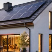 Modernes Einfamilienhaus mit Solaranlage auf dem Dach, als Beispiel für den Umgang mit Photovoltaik beim Hausverkauf. I Solaranlage